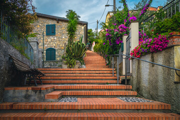 Fototapeta na wymiar Street view with flowery gardens and cozy walkway in Tellaro