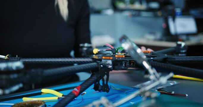 Engineer working on racing fpv drone combat kamikaze bomber in workshop.