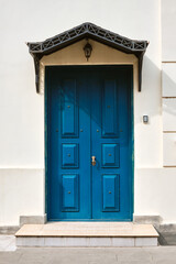 Beautiful blue wooden door against a white wall.