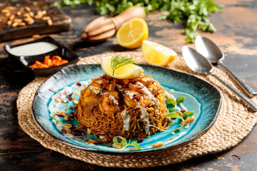 Machboos Prawns biryani rice with lemon slice served in dish isolated on table top view of arabic breakfast