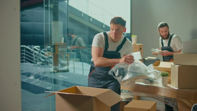 Workers of Moving Company With Uniforms Carefully Packing and Carrying Boxes. Shipping and Packaging Business Occupation Service Company. Preparation for a Long Trip, Transportation of Things
