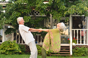  elderly couple dancing in nature in summer