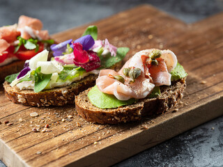 Variety of mini sandwiches with cream cheese, vegetables and salami