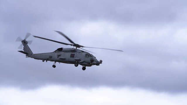 MH-60R Seahawk Helicopter Flying In Cloudy Sky - low angle