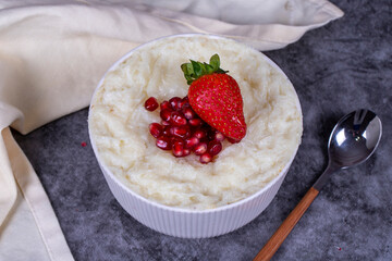 Gullac dessert. Traditional Ramadan dessert. Pomegranate and strawberry gullac dessert in bowl