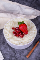 Gullac dessert. Traditional Ramadan dessert. Pomegranate and strawberry gullac dessert in bowl