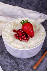 Gullac dessert. Traditional Ramadan dessert. Pomegranate and strawberry gullac dessert in bowl