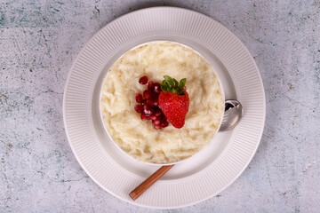 Gullac dessert. Traditional Ramadan dessert. Pomegranate and strawberry gullac dessert in bowl. Top view