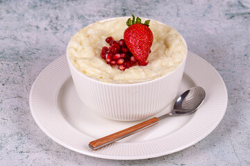 Gullac dessert. Traditional Ramadan dessert. Pomegranate and strawberry gullac dessert in bowl