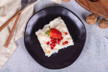 Gullac dessert. Traditional Ramadan dessert. Gullac dessert with pomegranate and strawberry on the plate. Top view