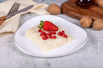 Gullac dessert. Traditional Ramadan dessert. Gullac dessert with pomegranate and strawberry on the plate