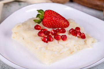 Gullac dessert. Traditional Ramadan dessert. Gullac dessert with pomegranate and strawberry on the plate. Close up