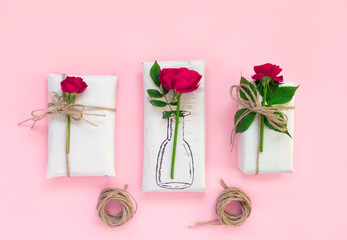 Set of wrapping paper and flowers for handmade on pink background. Homemade craft box gifts with painted vase, bouquet of red roses.