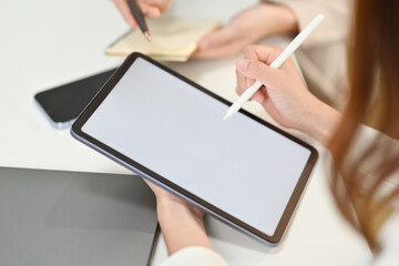 Close up view of creative woman holding stylus pen pointing at blank digital tablet screen