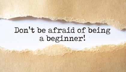 Don't be afraid of being a beginner. Words written under torn paper. Motivation concept text