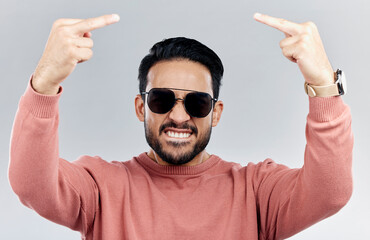 Portrait, rude and man with anger, middle finger and frustrated against grey studio background. Face, male and guy with offensive hand gesture, aggressive and conflict with expression and disrespect