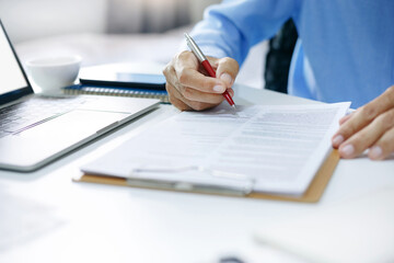 Asian businessman reviewing document reports at office workplace with computer laptop. legal expert, professional lawyer reading and checking financial documents or insurance contract