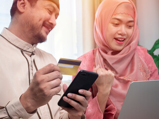 Online Shopping. Happy muslim couple using digital tablet and credit card buying and purchasing things