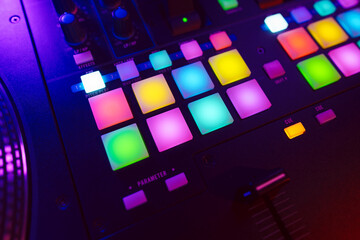 Close up of DJ mixing console in party light