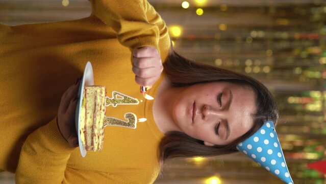 Beautiful happy young woman wearing sweater holding birthday cake number 47 golden candles burning by lighter. Concept of celebrating birthday and anniversary. POV.