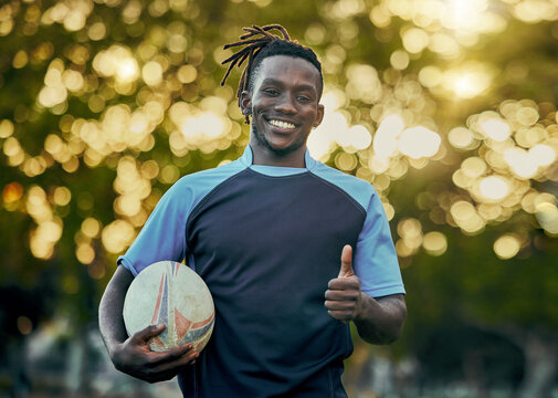 Rugby, thumbs up and portrait of black man with ball, confidence and pride in winning game. Fitness, sports and happy face of player ready for match, workout or competition at stadium in South Africa - Powered by Adobe