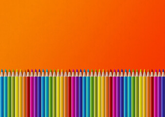 Colored pencil group isolated on orange. Horizontal background
