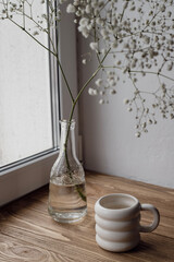 Fototapeta na wymiar A cup of coffee and flowers in a vase