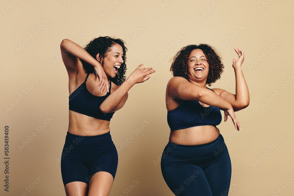 Wall mural youthful female friends enjoying a dance workout in a studio