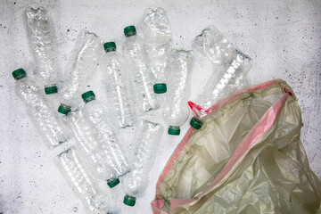 Recycling and ecology concept. Sorting household waste captured from above, flat lay. White concrete background empty plastic bottles