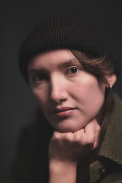 Studio Image of mid twenties girl, with half shaved head and with hat on