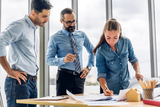 Professional of team architect industrial engineer cargo foreman working new construction project architectural plan with blueprint and construction tool on table at the building construction site