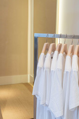 white t-shirts on hangers in the store