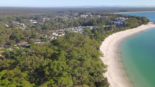 Aerial drone view of Huskisson in the City of Shoalhaven on the shores of Jervis Bay, NSW, Australia, traveling along Huskisson Beach on a bright sunny morning    