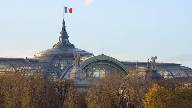 Roof of the Grand Palais with a French flag waving in the air in Paris, France in Autumn