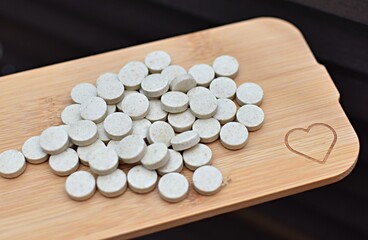 Fototapeta na wymiar pills are scattered on a wooden board from