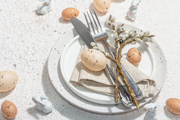 Easter table setting with eggs, rabbits and willow. Traditional festive symbols, greeting card