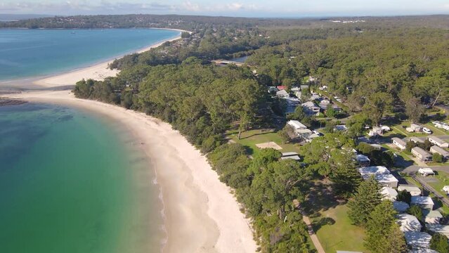 Aerial drone view of Huskisson in the City of Shoalhaven on the shores of Jervis Bay, NSW, Australia, heading toward Moona Moona Creek on a bright sunny morning    