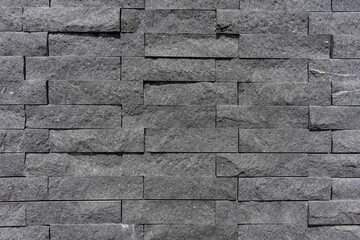 Texture of black, narrow bricks with a fine structure. Background of a black wall.