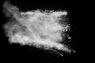 White powder explosion cloud against black background. White dust particles splash.