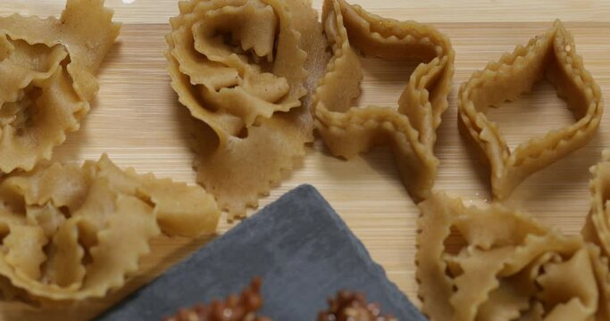 A closer look at culinary creativity: hands intricately shaping chebakia dough, turning it into a work of art