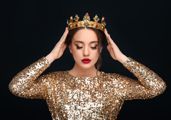 Beautiful young woman wearing luxurious crown on black background © New Africa