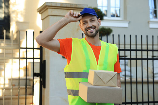 Courier in uniform with two parcels outdoors