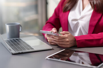 Close-up woman using smartphone to send text messages working or playing social media.