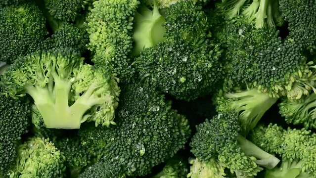 Broccoli slices with water drops. Wallpaper background of fresh organic broccoli cabbage with water drops.