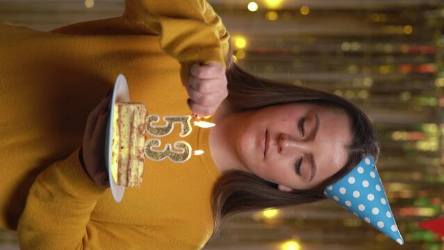 Beautiful happy young woman wearing sweater holding birthday cake number 53 golden candles burning by lighter. Concept of celebrating birthday and anniversary. POV.