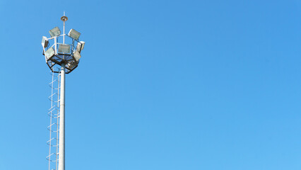 Street lighting pole isolated on blue sky background. Steel or metal illumination pole structure....