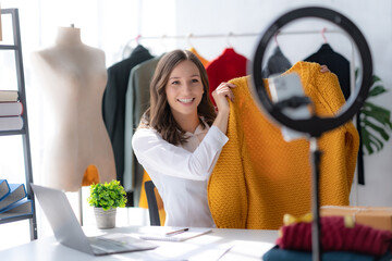 Charming woman designer are going live on their mobile phone selling their hand crafted and...