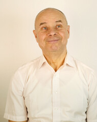 Fototapeta premium close up funny male face, bald mature man 60 years old, senior looks satisfied with life, aging skin, wrinkles, concept of human health, optimism in adulthood, midlife crisis