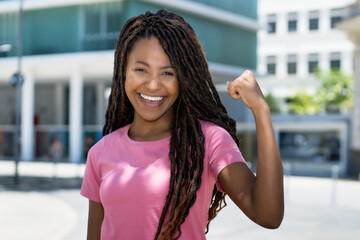 Successful cheering black woman with dreadlocks