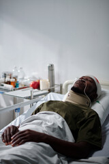Vertical image of African American soldier lying in hospital with wound